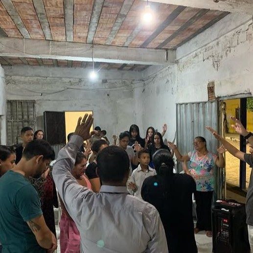 Congregação de mãos erguidas em um culto