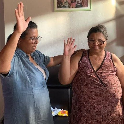 Oração ao lado de uma senhora, Bíblia aberta em mãos